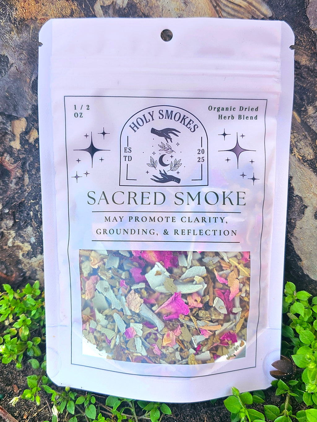 Package of 'Holy Smokes' Sacred Smoke blend on a natural background with herbs visible