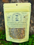 Packaged herb blend labeled 'Stardust Slumber' from Holy Smokes on a natural background.